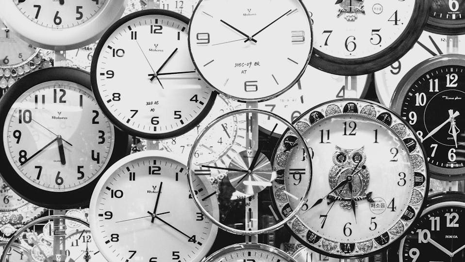 black and white photo of clocks that could be used for employee time tracking