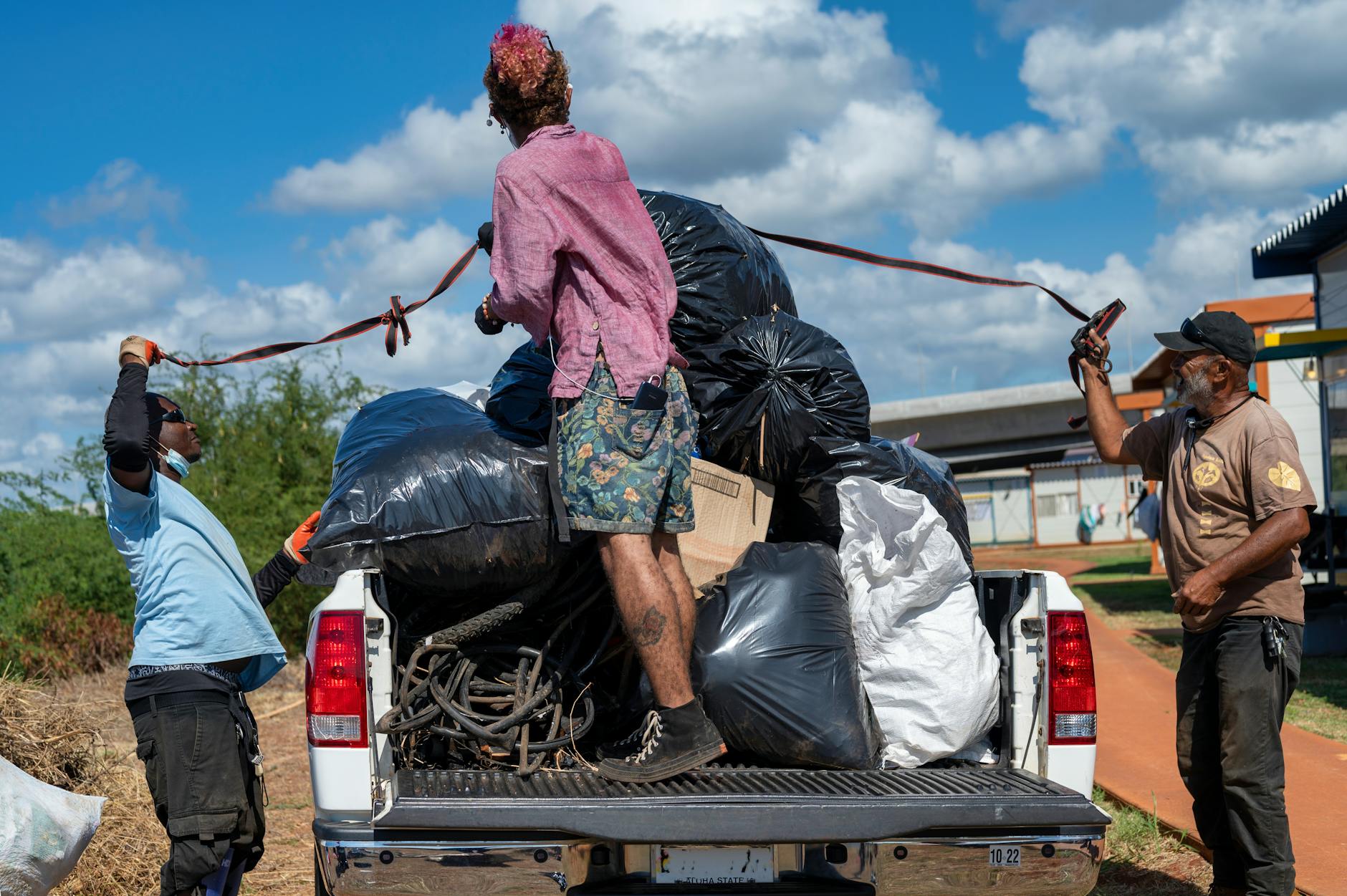 volunteers loading up the garbage bags in a pickup truck